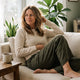 Woman sitting calmly on a sofa with a cup of tea — signs of gut microbiome imbalance